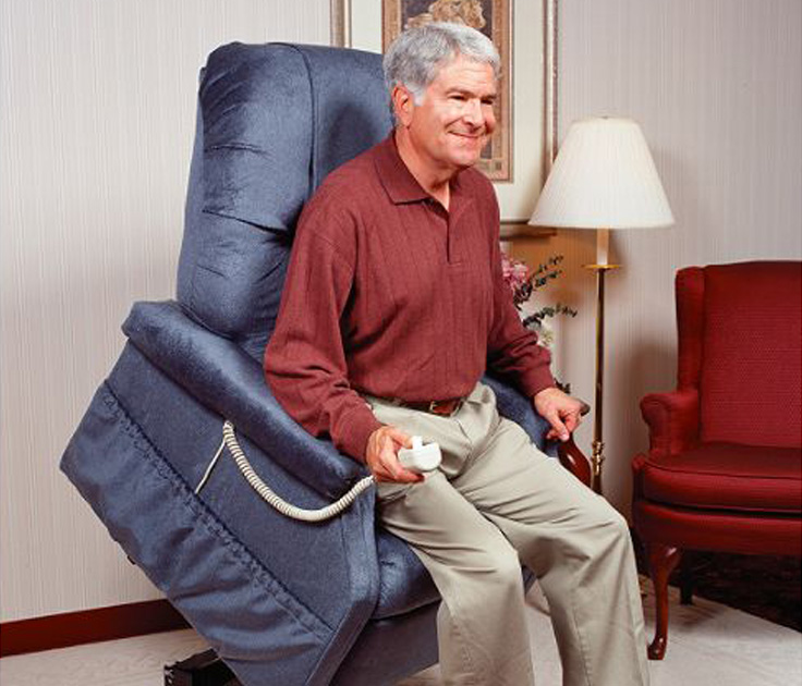 A smiling male senior citizen using a lift chair.